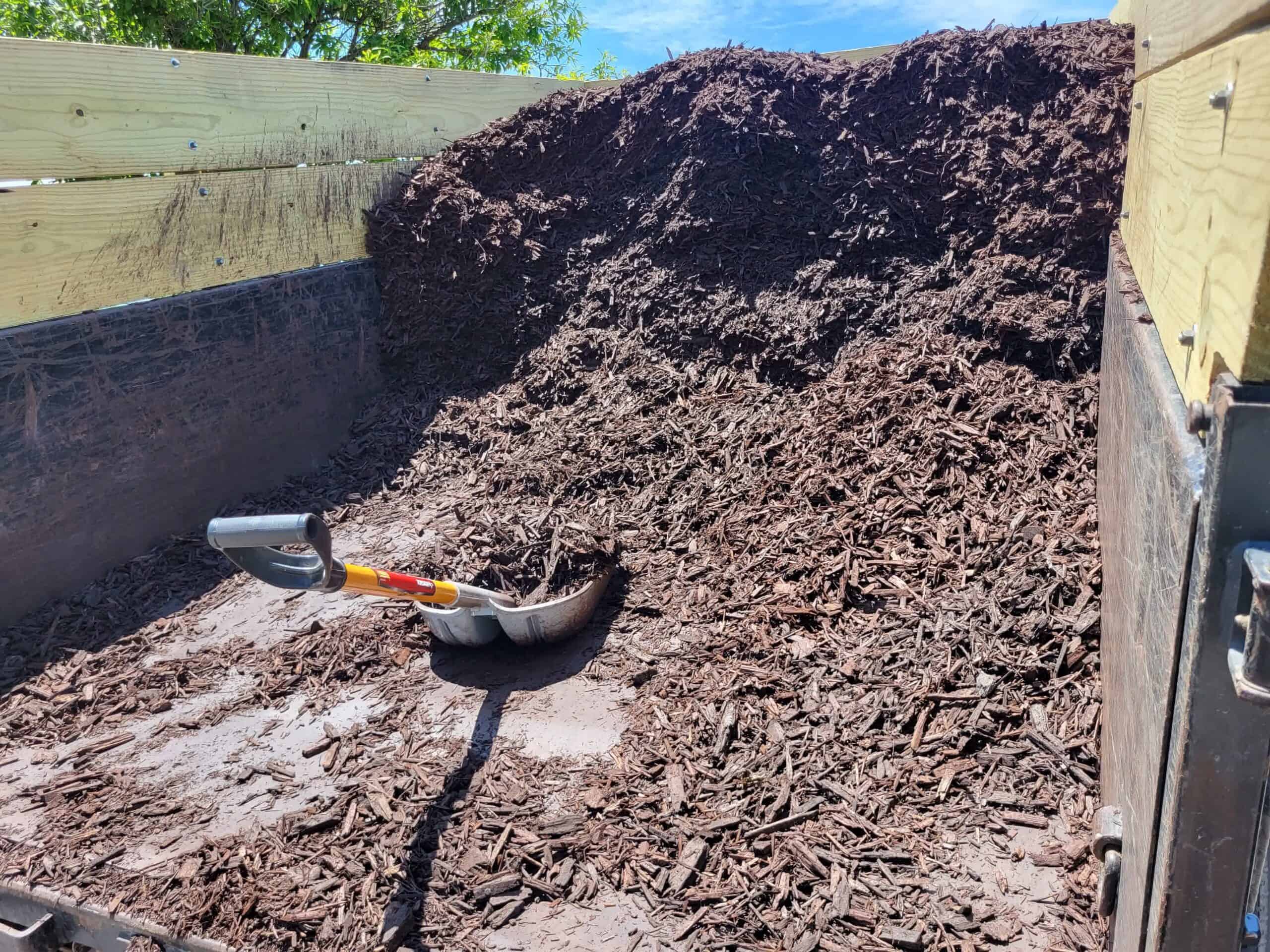 A work truck bed full of fresh mulch that is ready to be installed.