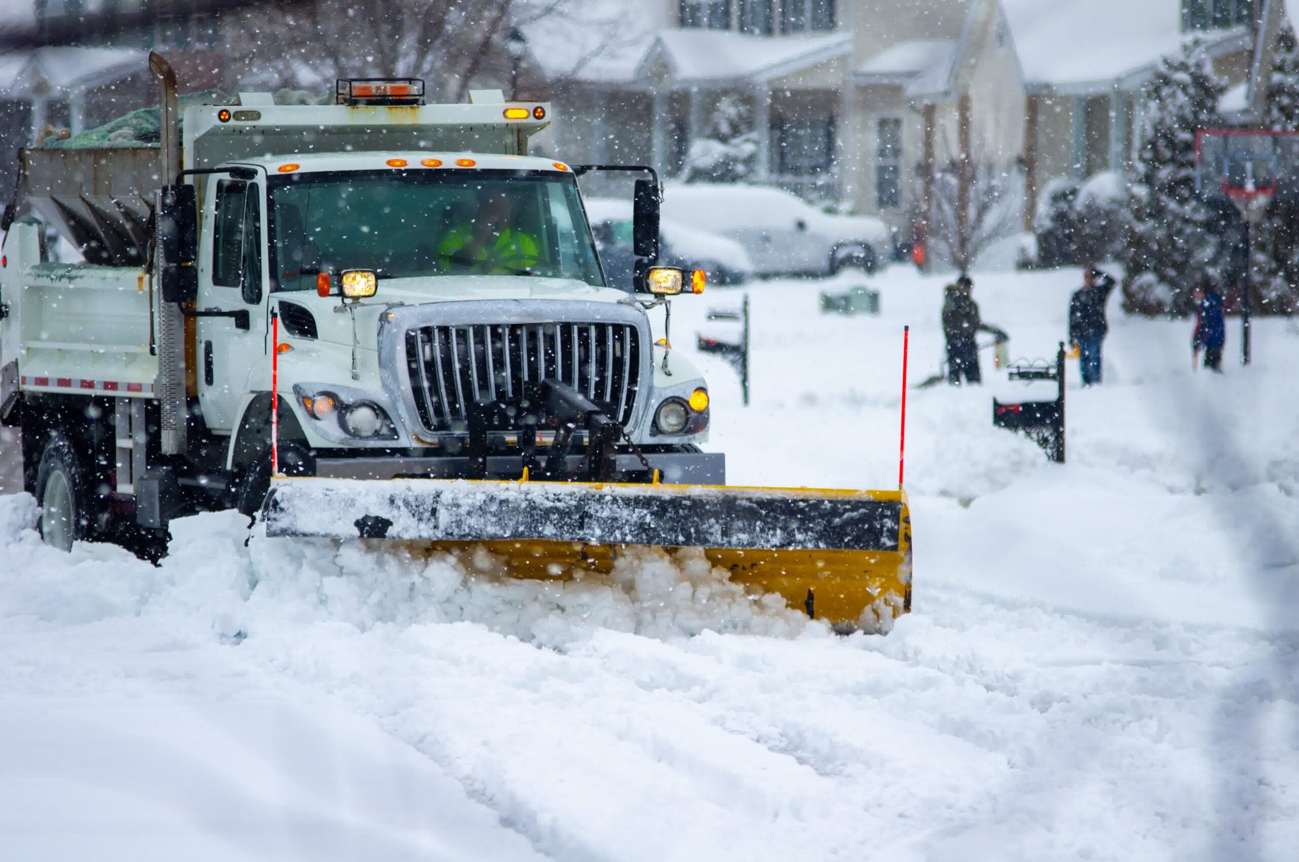 A truck applying deicing agents to snow on the road.