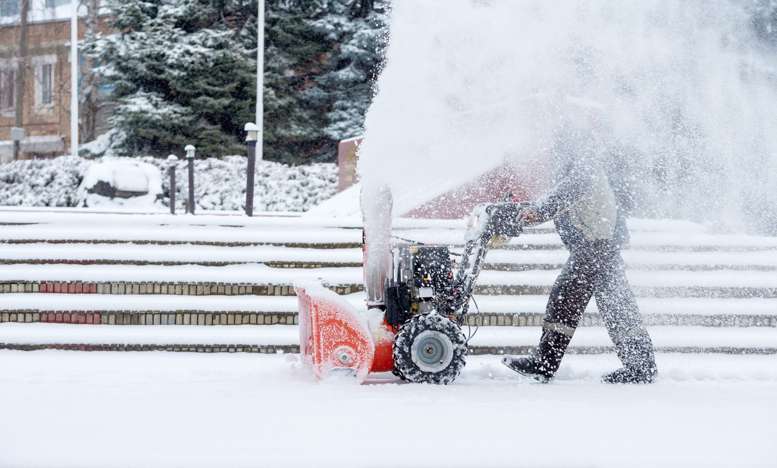 A man removing snow using a snow blower.