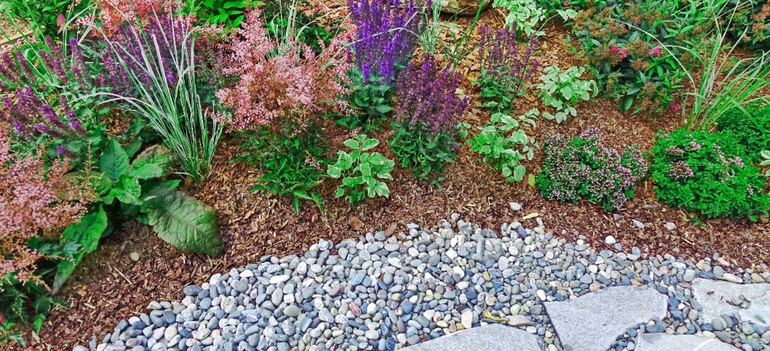 Fresh mulch that has been installed with vibrant plants and flowers.