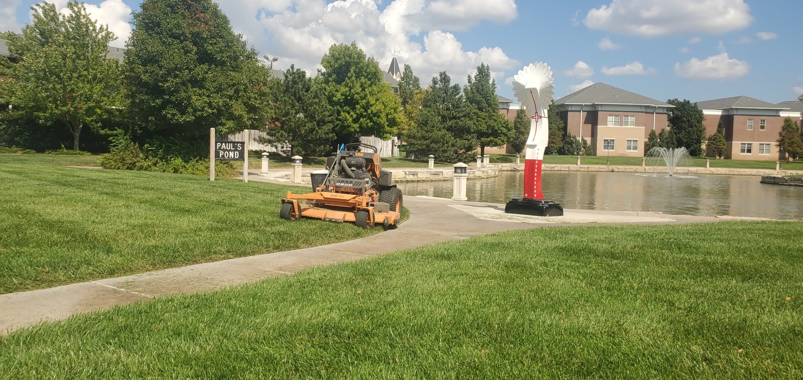 One of our riding mowers posing next to its masterpiece of a lawn.